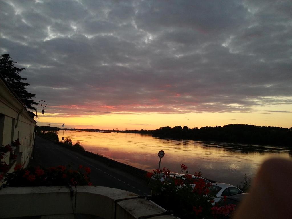 a view of a river with the sunset in the background at le prieuré in Montsoreau