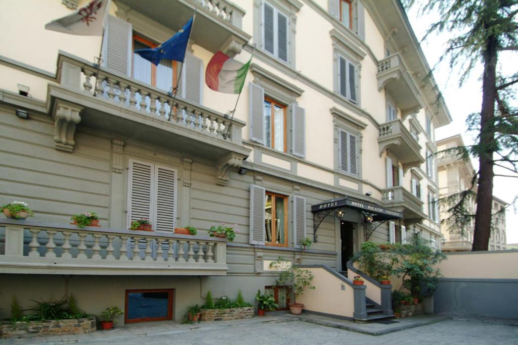 ein Gebäude mit zwei Flaggen auf der Seite in der Unterkunft Hotel Palazzo Vecchio in Florenz