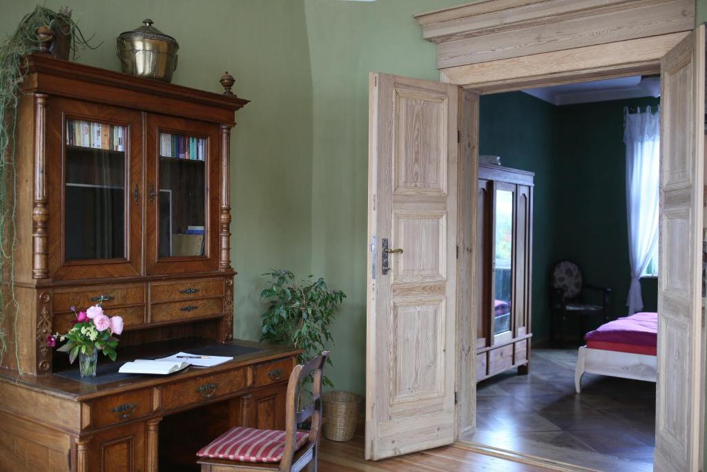 a room with a wooden desk and a bedroom at Ökologische Ferienwohnung in Bad Wilsnack