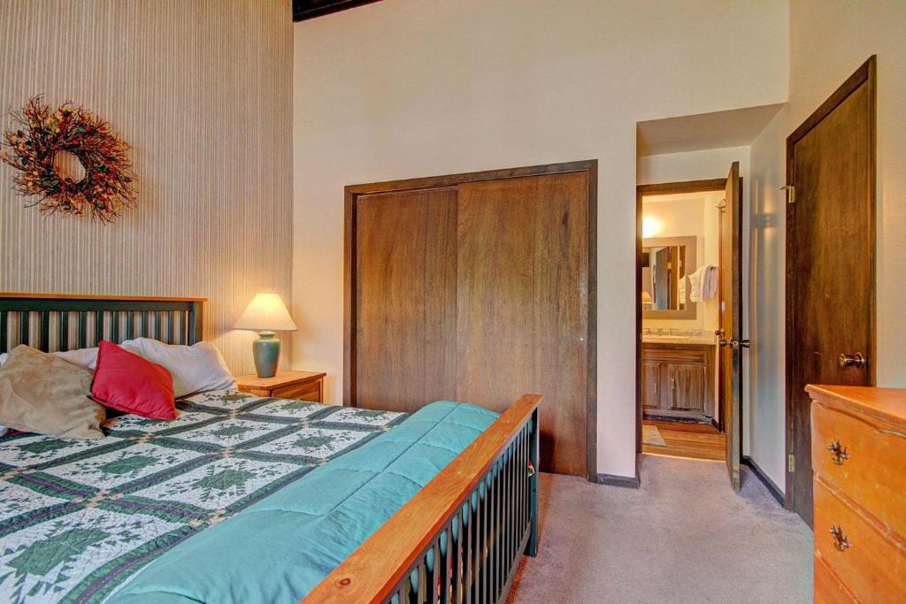 a bedroom with a bed with a wooden headboard at Herbage E1 Townhouse Close to City in Steamboat Springs