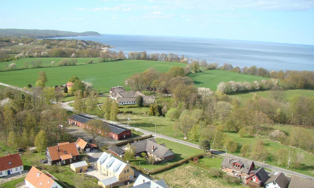 an aerial view of a house with a field and the ocean at STF Baskemölla Hostel in Simrishamn