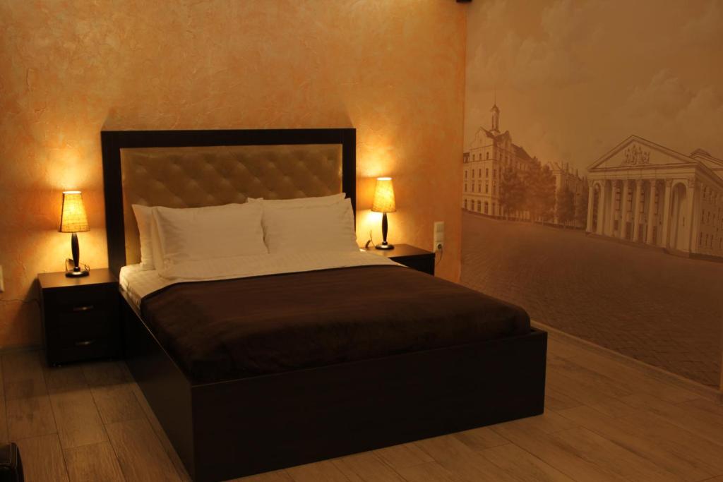 a bedroom with a large bed with two lamps at Apartment on Prospekt Mira in Chernihiv