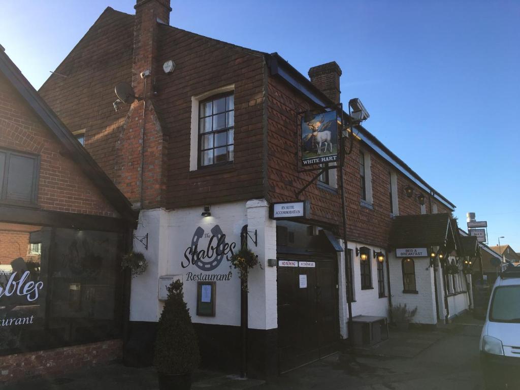 a building with a sign on the front of it at The White Hart pub and rooms in Cranleigh