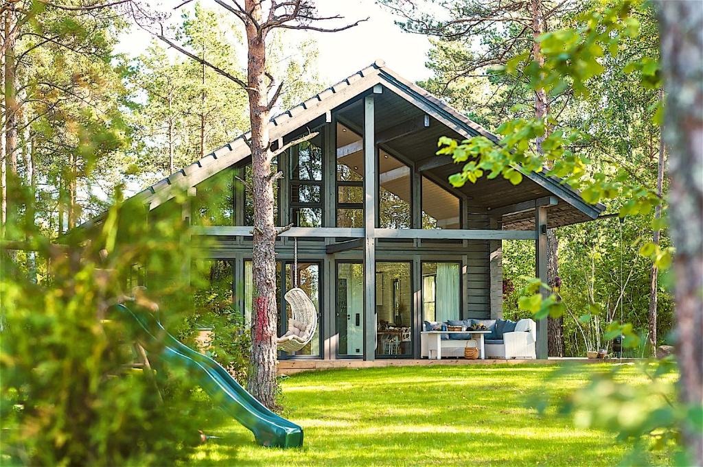 a glass house with a slide in the grass at Hapsal Spa Villas in Haapsalu