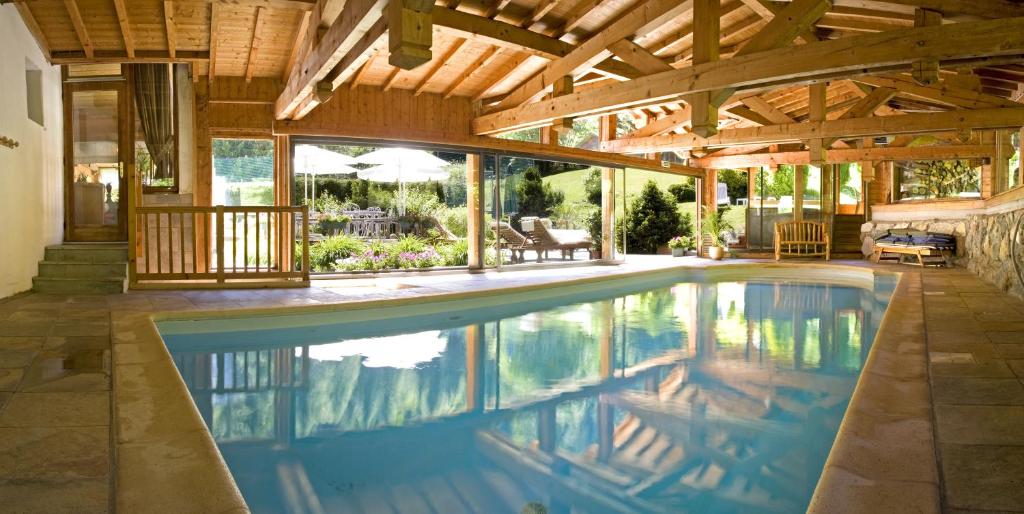 an indoor swimming pool in a house with a wooden ceiling at Hôtel Le Jeu de Paume in Chamonix-Mont-Blanc