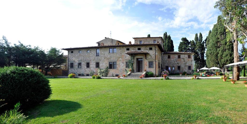 Villa Medicea Lo Sprocco في سكاربيرا: منزل حجري كبير مع ساحة كبيرة