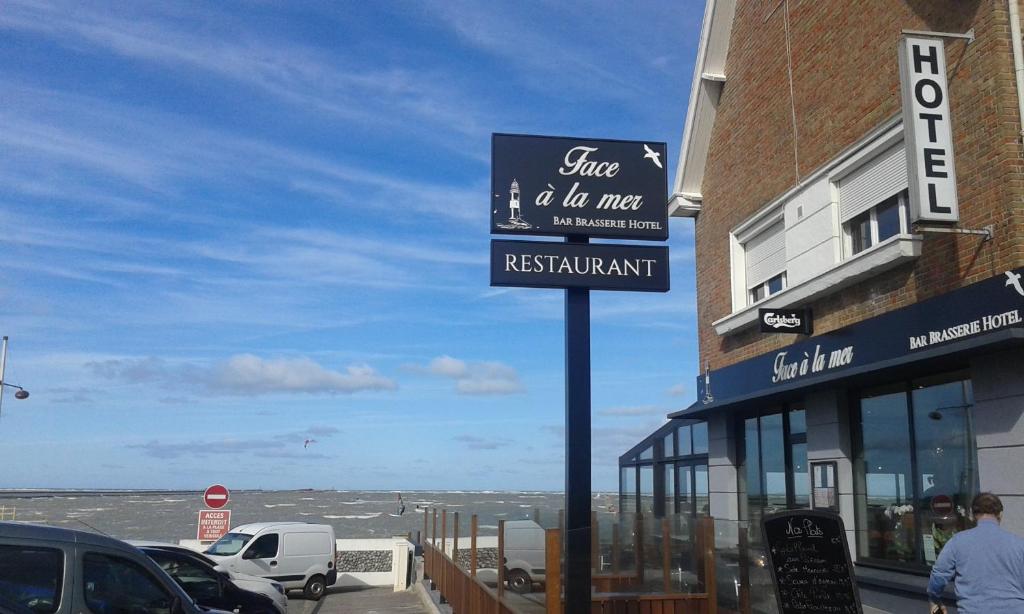 a sign for a restaurant in front of a building at Face à la mer in Gravelines