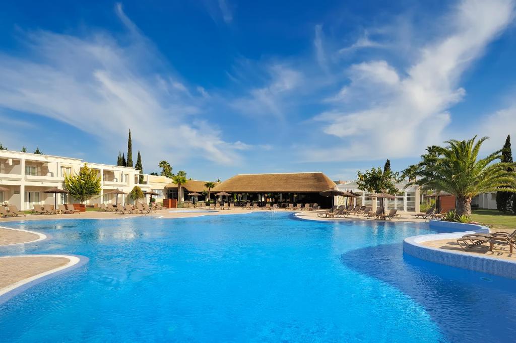 
a large swimming pool with a blue sky at Vincci Resort Costa Golf in Chiclana de la Frontera
