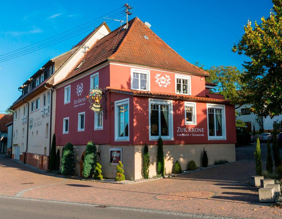 a red and white building on the side of a street at Landhotel Restaurant zur Krone in Gottenheim