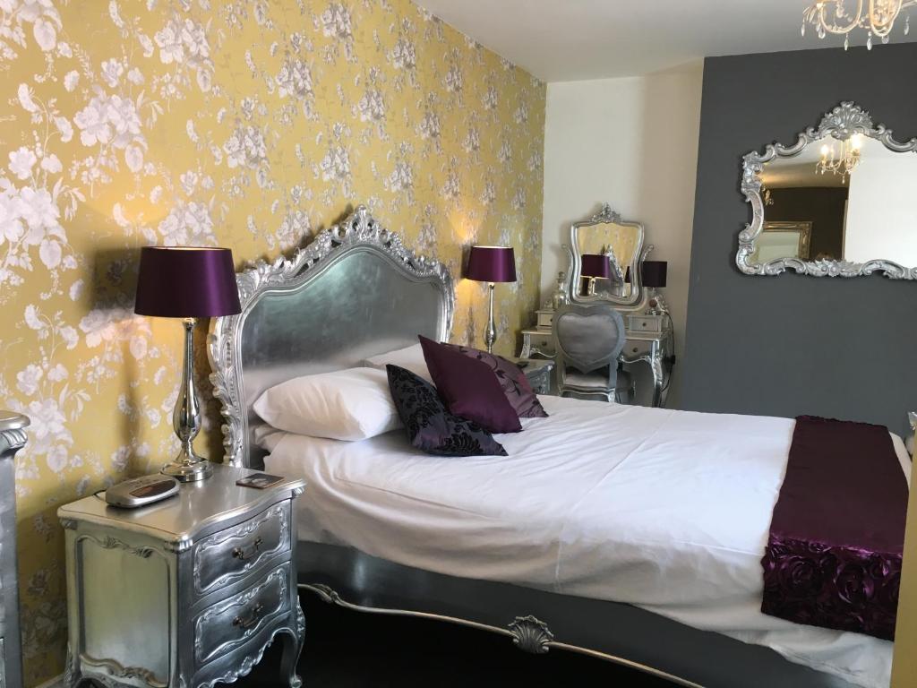 um quarto com uma cama e um espelho em tiger inn em Bridport