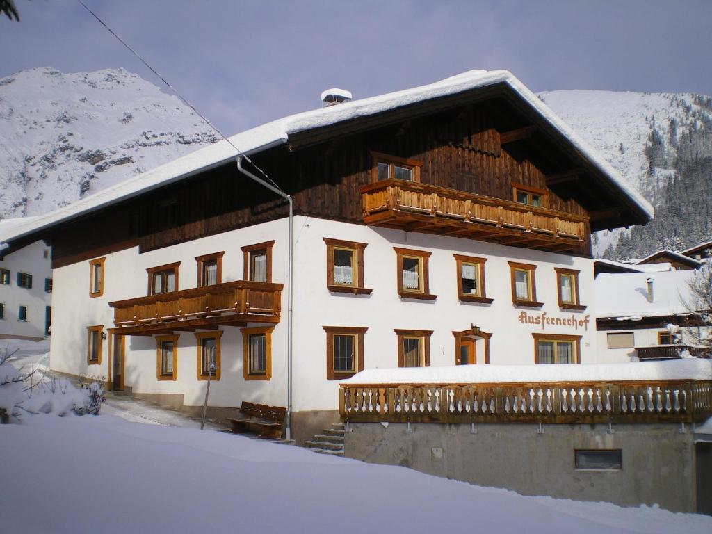 un grand bâtiment avec de la neige au sol dans l'établissement Ausfernerhof, à Berwang