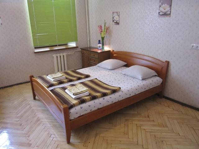 1 dormitorio con cama de madera y ventana verde en Yaroslav Hostel en Kiev