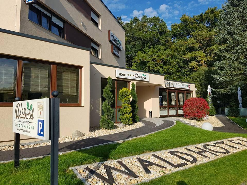 un hotel con un cartel frente a un edificio en Waldhotel Sindelfingen am Eichholz, en Sindelfingen