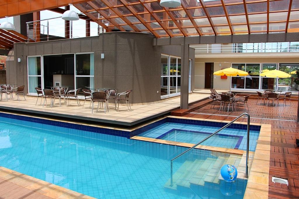 马沙蒂纽Hotel Villa das Termas Machadinho的一个带椅子和桌子的大型游泳池