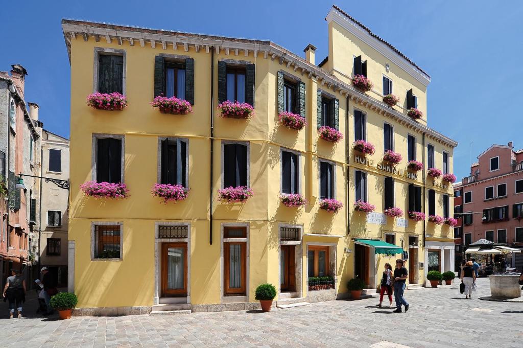 un edificio giallo con fioriere sopra di Hotel Santa Marina a Venezia