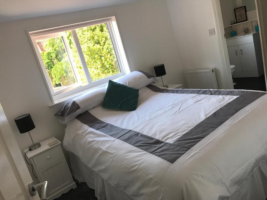 a bedroom with a large bed with a window at Wolds Cottage Pocklington in Pocklington
