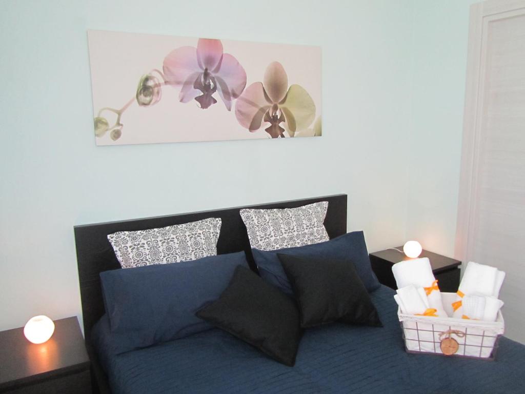 - une chambre dotée d'un canapé bleu avec des oreillers et des fleurs sur le mur dans l'établissement B&B Il Giardino In Città - Parcheggio Privato Gratuito, à Foggia
