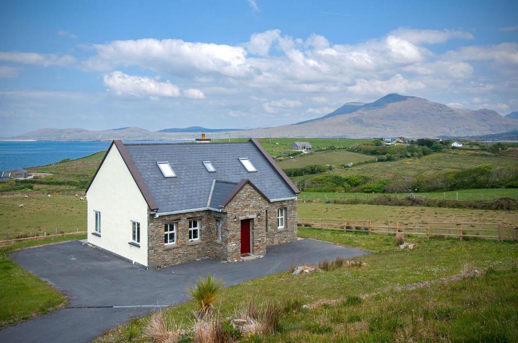 una casa su una collina con l'oceano sullo sfondo di Cottage 259 - Renvyle a Renvyle