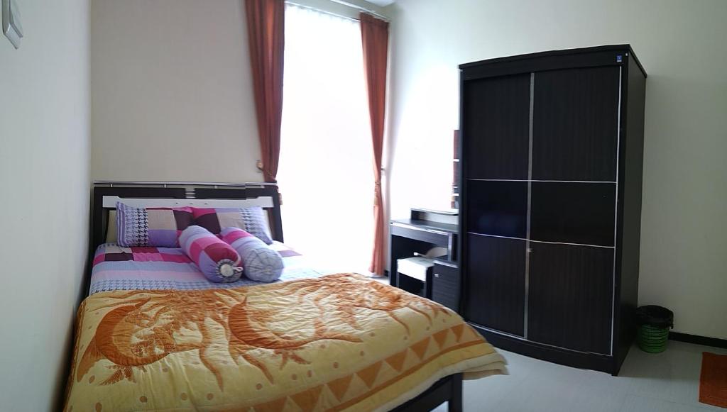 - une chambre avec un lit et une grande fenêtre dans l'établissement Villa Keluarga Batu, à Batu