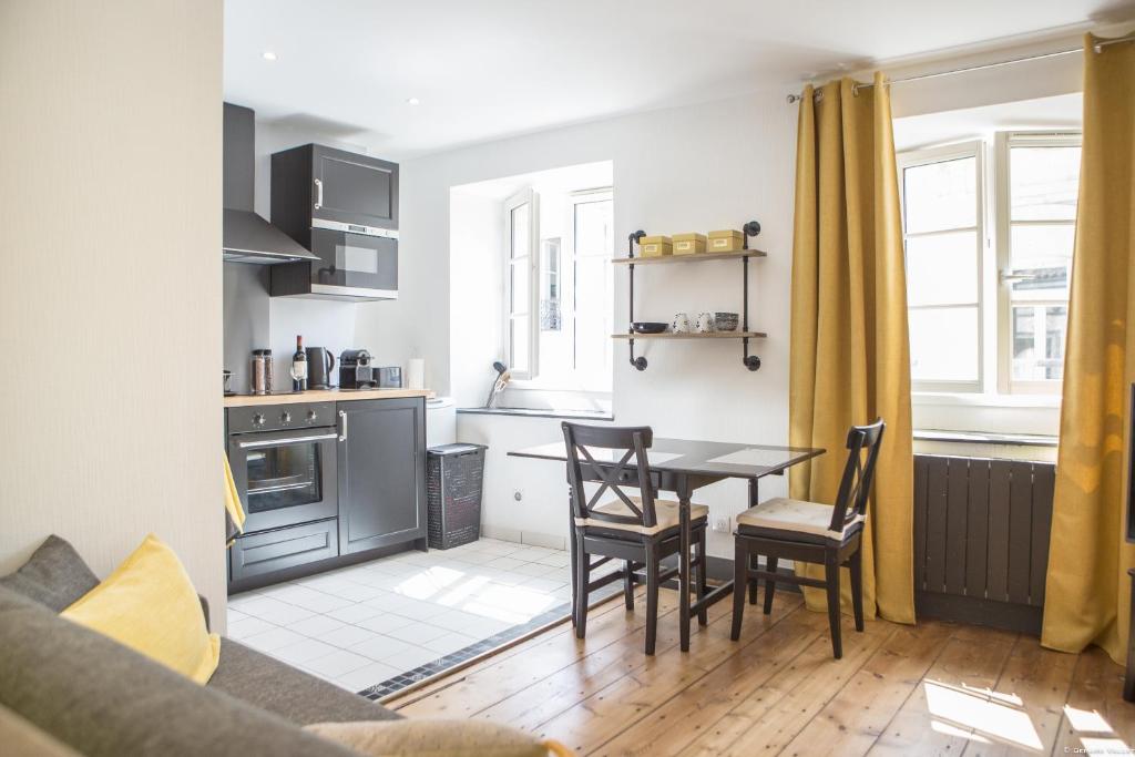 une cuisine et une salle à manger avec une table et des chaises dans l'établissement Place du Palais 3°, à Bordeaux