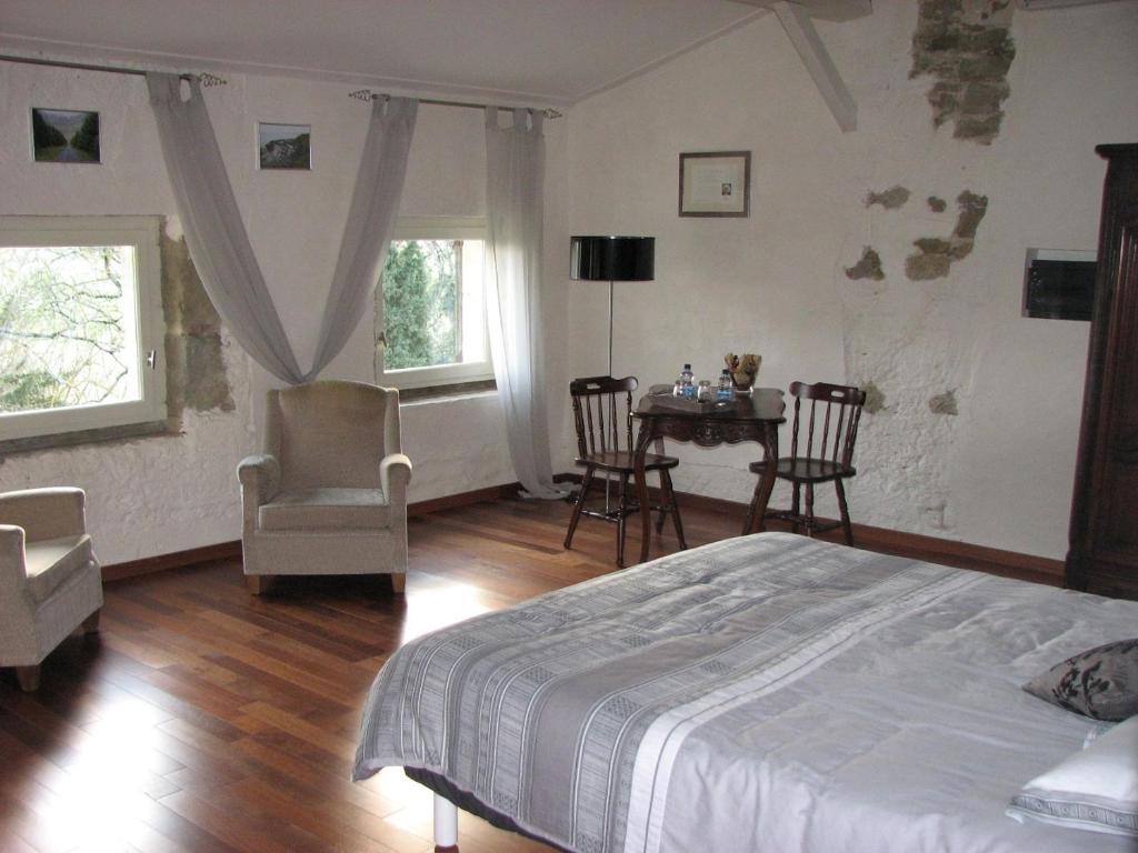 1 dormitorio con 1 cama, mesa y sillas en Chambres d'Hôtes Domaine Saint-Joly, en Lasbordes