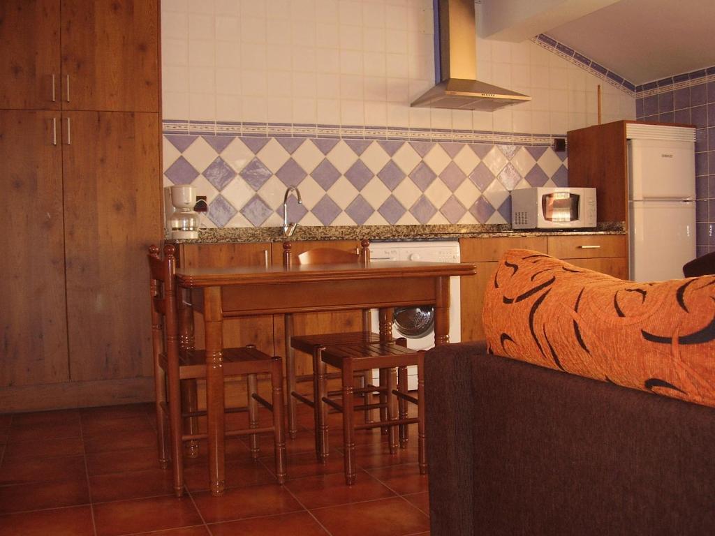cocina con fregadero y mesa con taburetes en El Magnolio, en Santillana del Mar