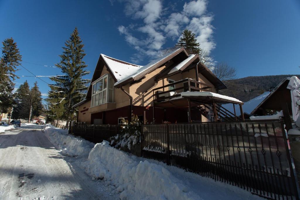 una casa con una valla en la nieve en Casa Anne Marie, en Sinaia