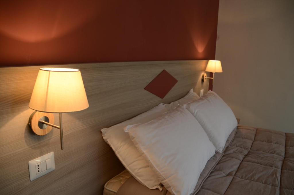 a bedroom with a bed with a lamp next to it at Kaliè Rooms Guest House in Cagliari