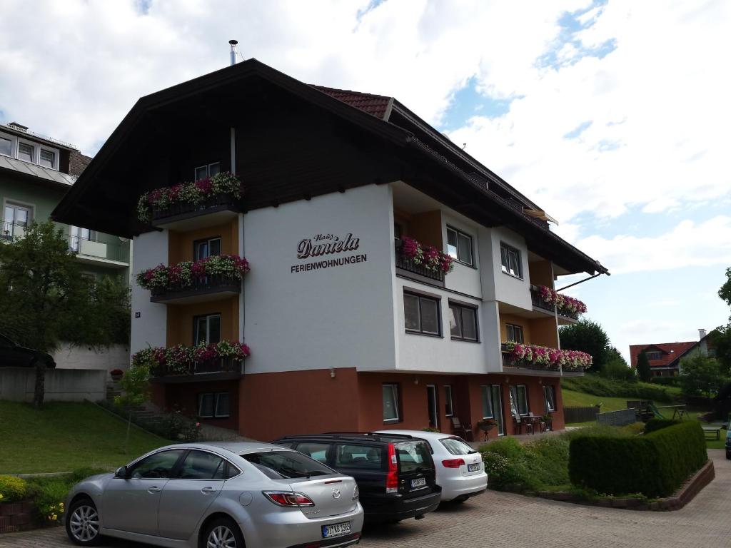 a building with cars parked in front of it at Haus Daniela in Drobollach am Faaker See