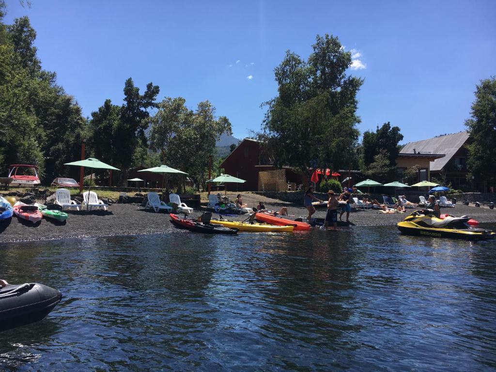 a group of people on a river with boats at Cabañas Huelquehue in Licán Ray