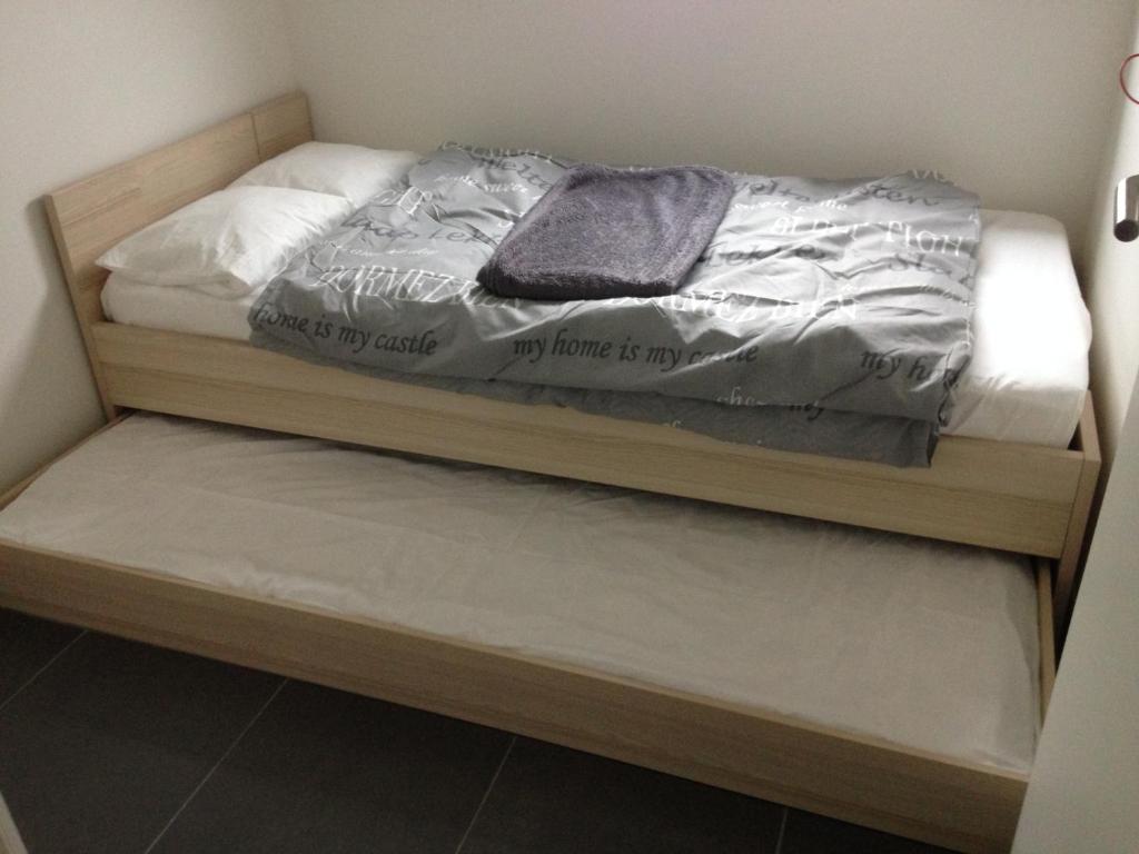 uma cama com uma cama de madeira com um cobertor em walhofpark nr 25 em De Panne