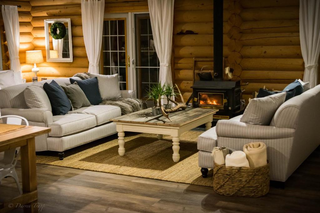 ein Wohnzimmer mit 2 Sofas und einem Kamin in der Unterkunft Whitewater Lodge in Golden