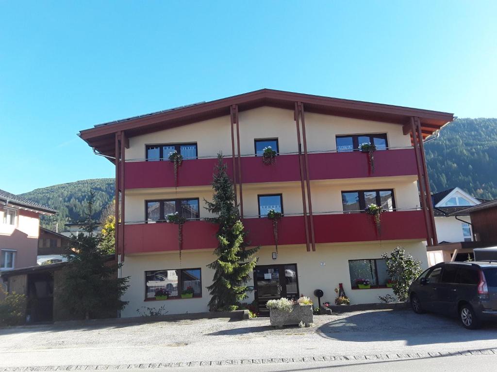 ein großes Gebäude in Rot und Weiß in der Unterkunft Family-Appartements in Innsbruck
