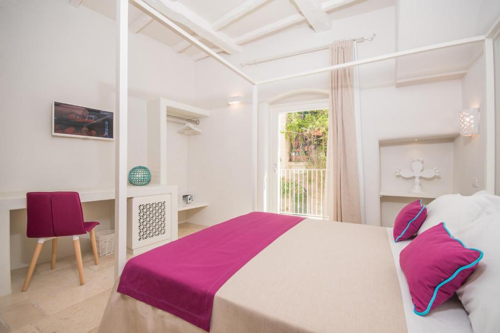 um quarto com uma cama grande e uma janela em Palazzo Maringelli em Polignano a Mare