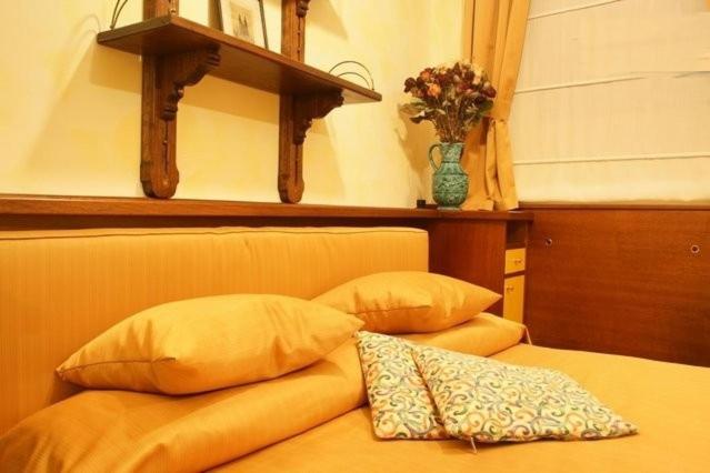 ein Bett mit zwei Kissen und einer Vase an der Wand in der Unterkunft Residence Týnská in Prag