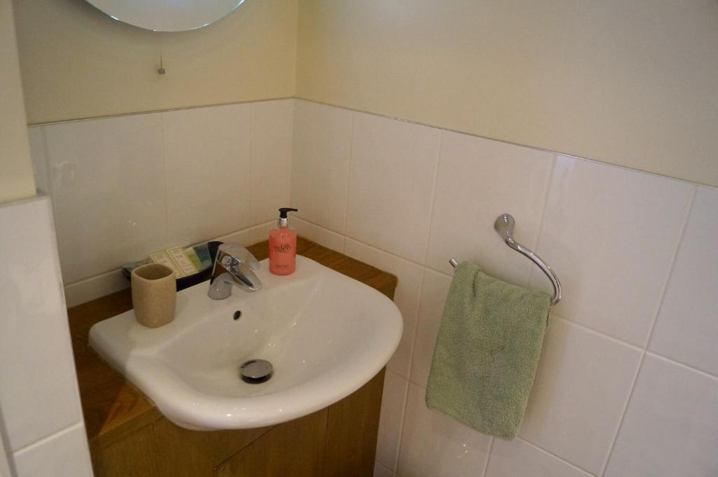 a bathroom with a sink and a green towel at The Arun View Inn in Littlehampton
