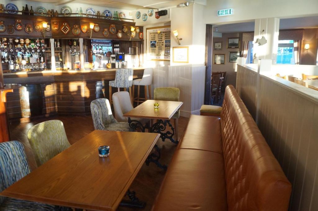 a restaurant with wooden tables and chairs and a bar at The Arun View Inn in Littlehampton