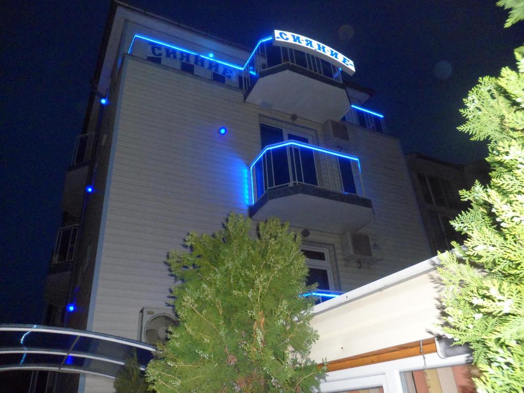 un edificio con luci blu sul lato di Sianie Guest House a Ravda