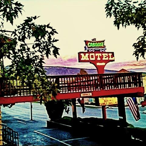a woman sitting on a bench at a motel at Caboose Motel & Gift Shop in Durango