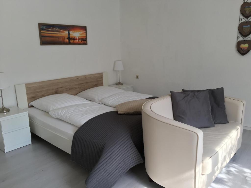 a bedroom with a white bed with a white headboard at Das Ostseehotel in Hohwacht