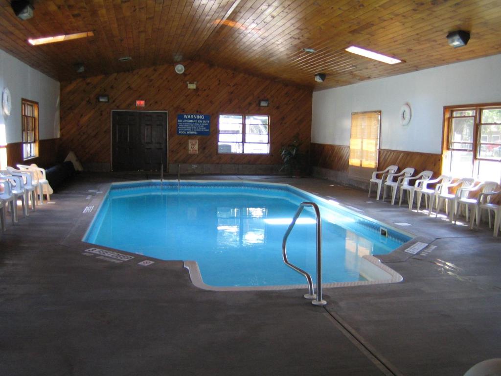 uma grande piscina com cadeiras ao redor em Villager Motel & Glen Manor Estate em Watkins Glen