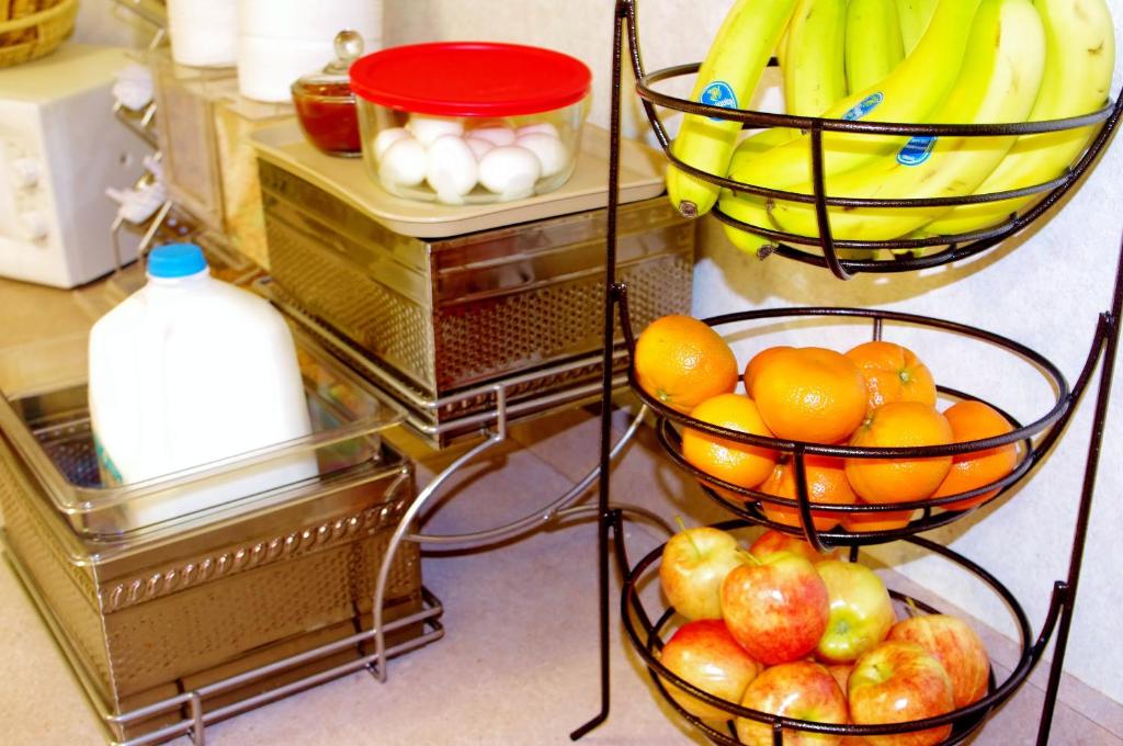 two baskets of fruit on a shelf with bananas and apples at Glenwood Springs Cedar Lodge in Glenwood Springs