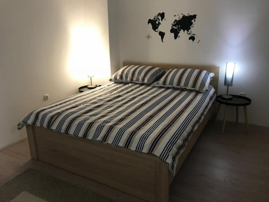 1 dormitorio con 1 cama con mapa en la pared en Orhideja Osijek, en Osijek