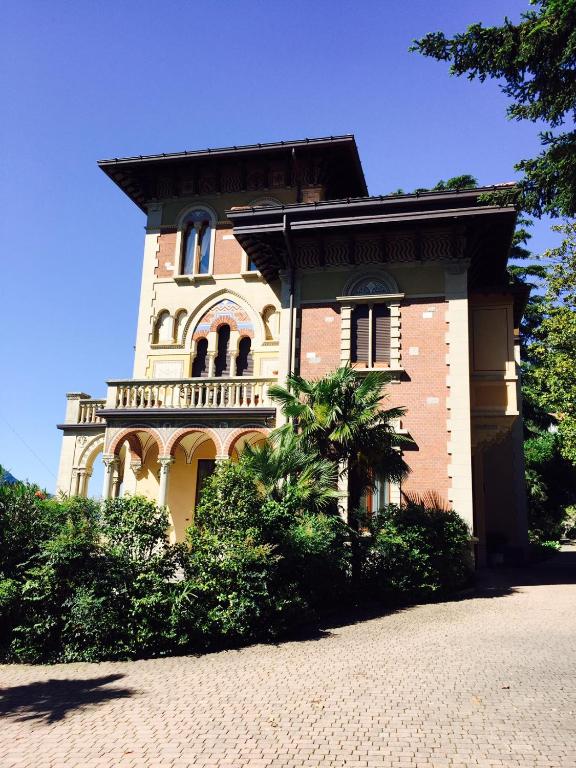 a large brick building with a balcony on it at Villa Castiglioni Luxury Apartment in Laglio