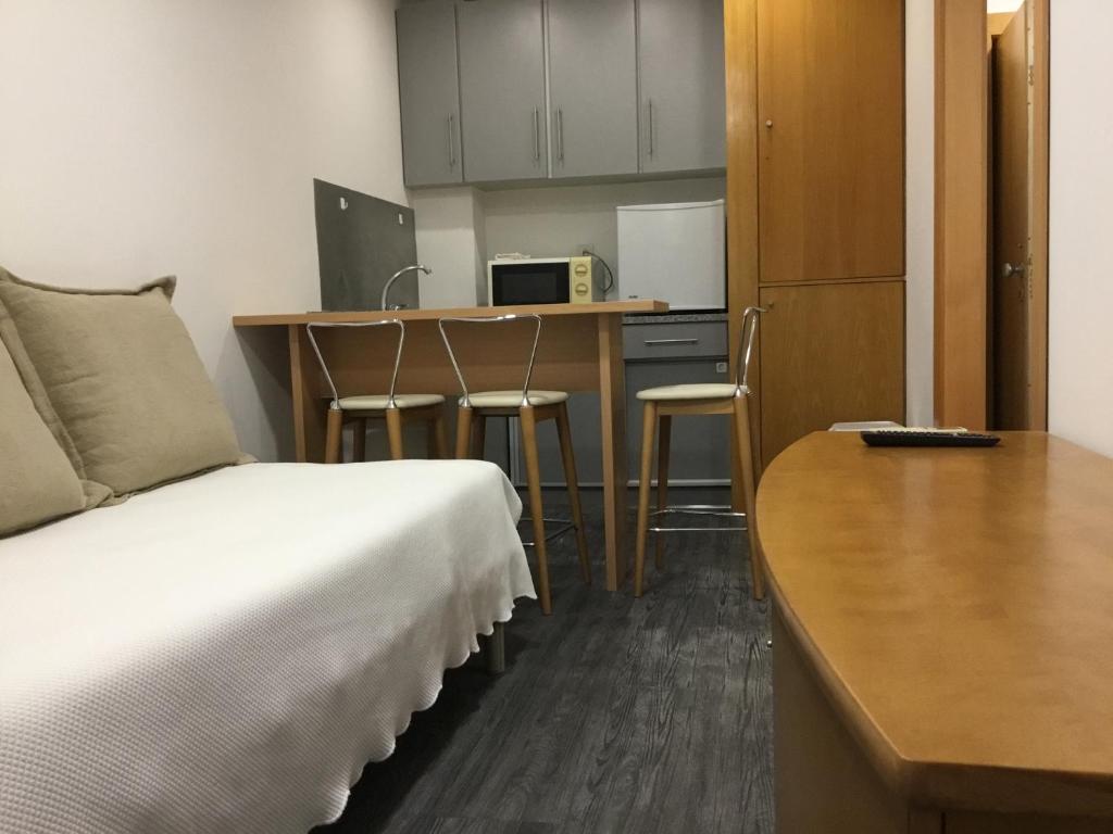 een kamer met een bed, een bureau en een keuken bij Seculo apartments in Porto