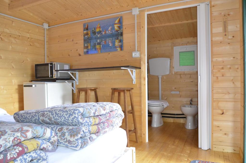 una baita di tronchi con cucina e servizi igienici di Camping Adamello a Edolo