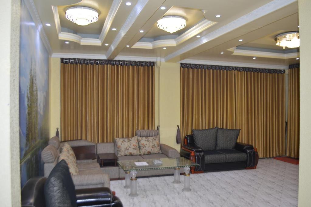 a living room with a couch and chairs and a table at Hotel Reyadha International in Cox's Bazar