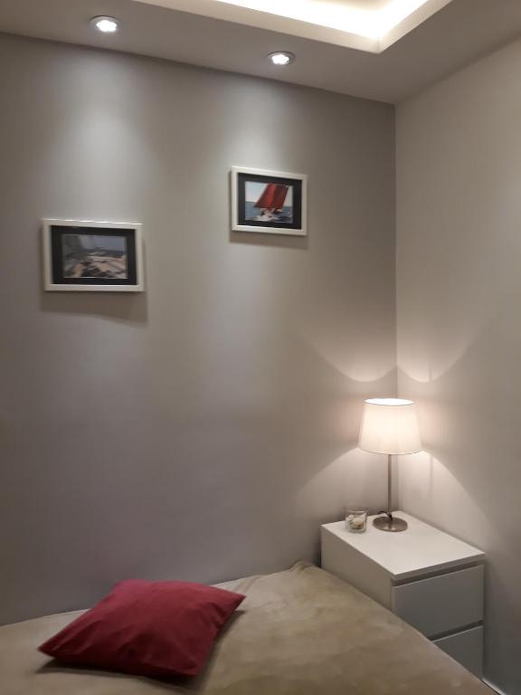 sypialnia z łóżkiem, lampą i dwoma obrazami na ścianie w obiekcie Apartament Marina w mieście Sopot