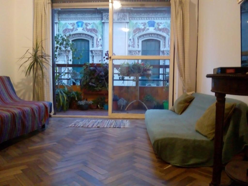 Cette chambre dispose d'une chaise et d'une porte avec fenêtre. dans l'établissement Rosario microcentro 3 dormitorios. Downtown 3 bedroom, à Rosario