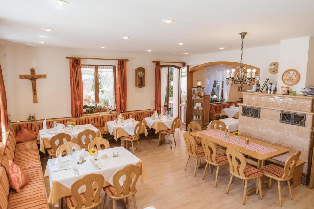 a restaurant with tables and chairs and a cross on the wall at Hotel-Restaurant Gasthof Adler in Neuenburg am Rhein